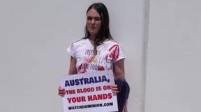 在披着红色斑点澳大利亚国旗的邦宁斯香肠外举行的素食抗议活动