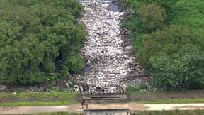 由于累积的垃圾量，人在河上散步