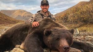 猎人在与他杀死的大熊摆姿势后收到了恶毒的死亡威胁