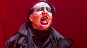 Marilyn Manson在群众射击市的人群中瞄准假步枪