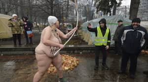 裸体妇女与'of f ***离开'写在乌克兰议会外的身体上