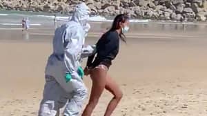 Covid-19检测呈阳性后，一名身穿防毒服的女子因冲浪被警方逮捕
