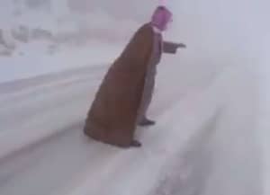 在沙特阿拉伯经历随机暴风雪时，看着这家伙滑上冰上