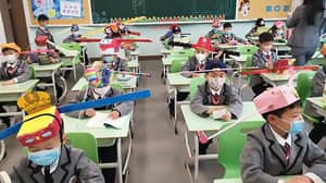 当他们回到学校时，中国的学生穿着自制的社会疏远帽子
