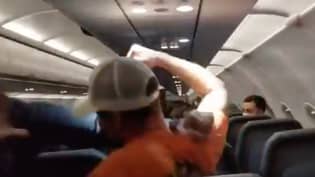 乘客在冲压和摸索的空姐后坐在座位上的座位