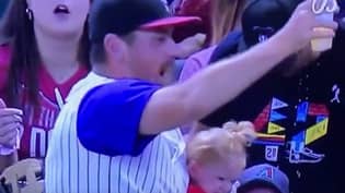 爸爸在棒球比赛中接球时设法弄乱了他的婴儿和啤酒