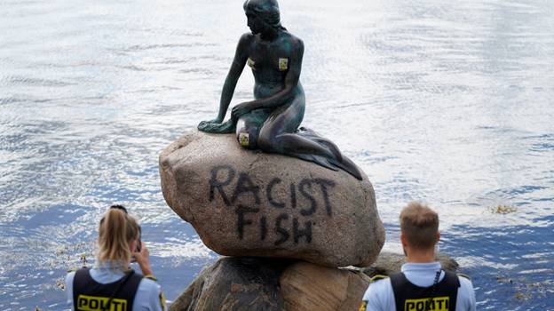 在丹麦的小美人鱼雕象毁了与'种族主义鱼'涂鸦