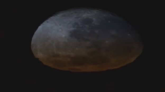 稀有镜头显示月亮在轨道日落中融化