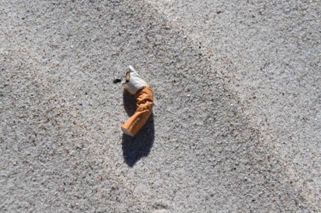 躺在海滩上的香烟屁股。信用：PA