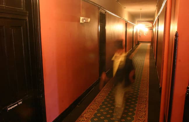一个可怕的人物踩着走廊（实际上只是一个以缓慢的快门速度拍摄的顶礼帽的家伙）。信用：PA