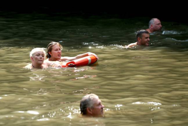 游泳在汉普斯特德希思的混合的沐浴池的人们游泳。信用：PA