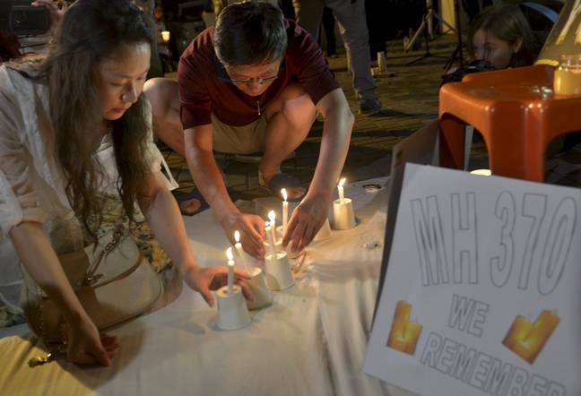 凯利·温（l）是中国乘客李的妻子，他在守夜期间在MH370上登上一支蜡烛。信用：PA