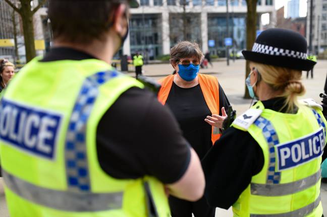 警方在分解曼彻斯特的抗议活动后与NHS工人Karen Reissmann交谈。信用：PA