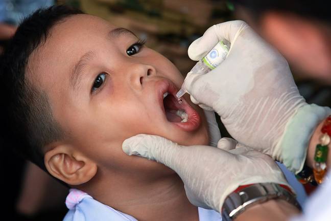 一个男孩在反脊髓灰质炎运动期间接受口腔脊髓灰质炎病毒疫苗。信用：PA