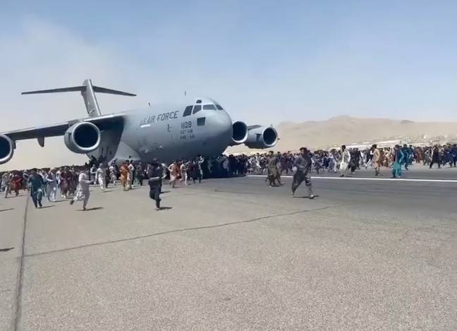 看到人们紧紧抓住美国空军货物，试图逃离阿富汗。信用：Twitter