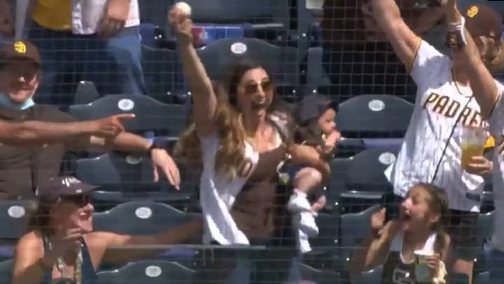 妈妈在抱着婴儿的同时，在棒球比赛中获得了令人难以置信的单手接球
