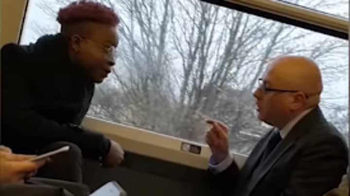 女人在挤满火车上使用种族诽谤反对男人