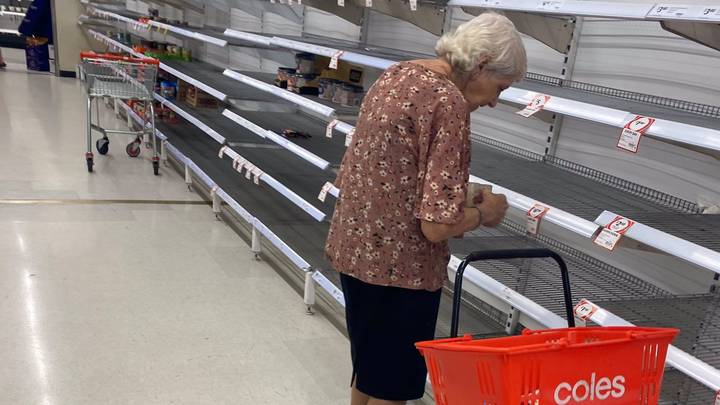 在空超级市场的​​老年妇女'泪水亮点恐慌购买危机