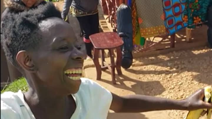 乌干达女人在被送给第一双鞋后快乐地跳舞
