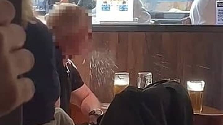男人在酒吧Sparks吐啤酒的视频有关冠状病毒的辩论