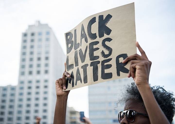 在“黑人生活事项”抗议活动中面对警察的妇女的“标志性”形象传播