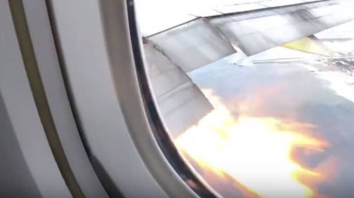 恐怖的乘客惊恐地看着飞机翼的火焰爆炸